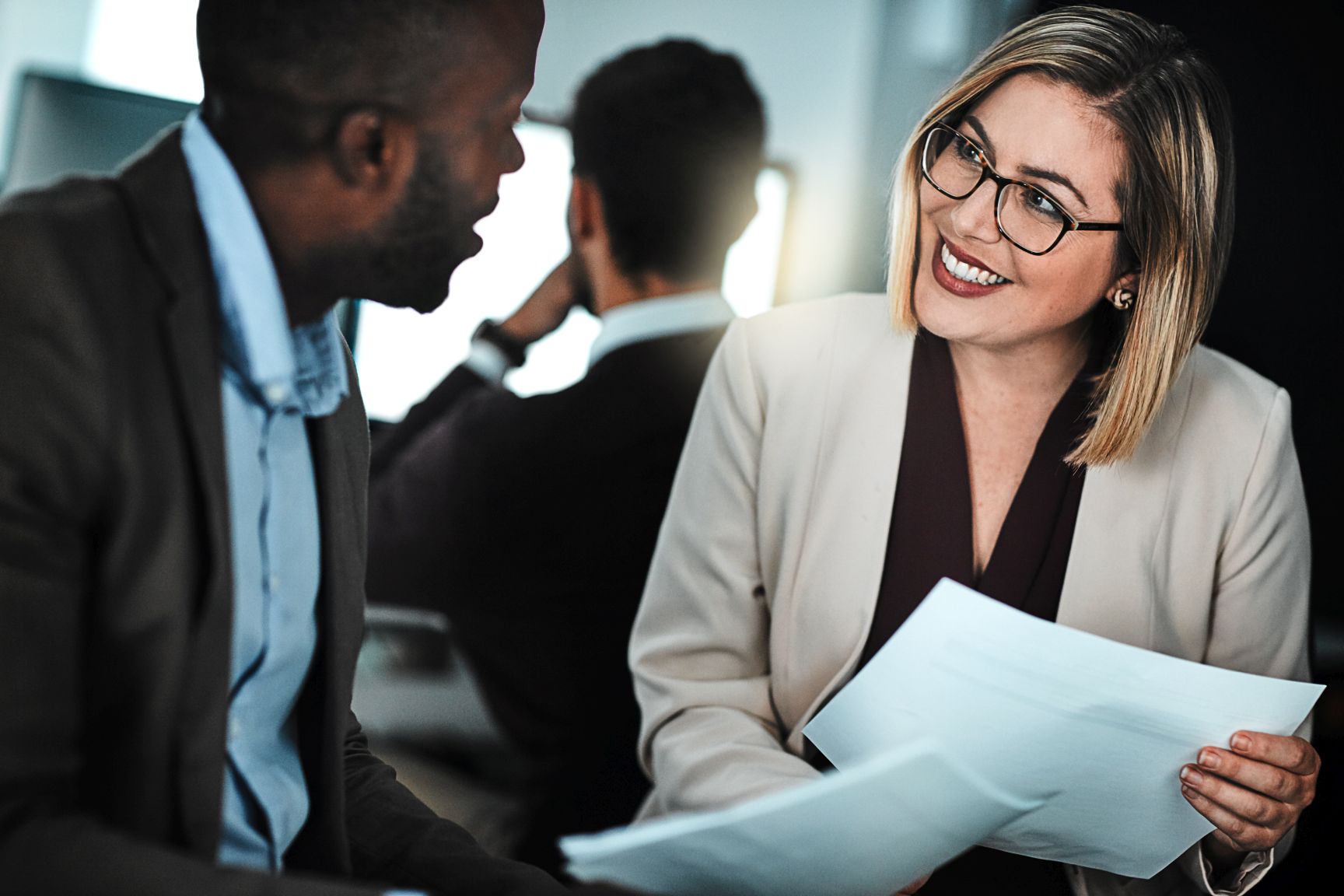 Shes eager to go beyond her domain. two businesspeople discussing paperwork.